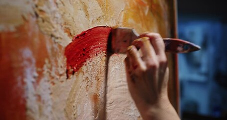 Cinematic macro of female creative artist painter concentrated and inspired painting colorful abstract picture with paint brush and oil colors on canvas while working on new masterpiece for exhibition - Powered by Adobe