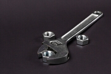 Wrench and screw-nuts on a Dark Textured Background
