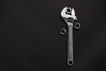 Wrench and screw-nuts on a Dark Textured Background