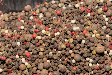 Mixture of dried round hot red pepper, black pepper, white pepper, green pepper as background