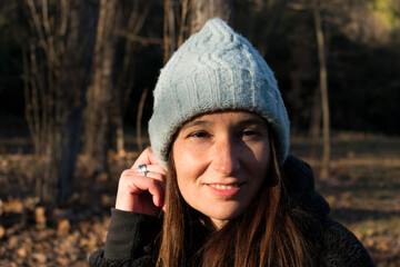 Smiling young woman wearing a hat in the forest