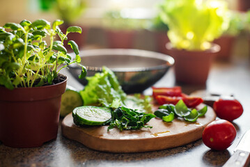 Slices of cucumber, tomatoes, spinach on a cutting board, ingredients for salad.