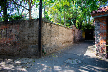 Houses and stone wall in alley from Mexico City