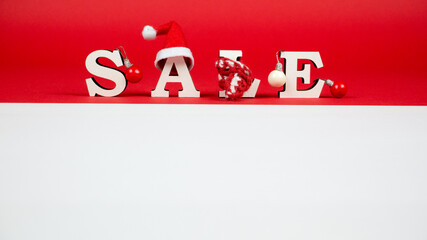 Wooden letters forming the word SALE. New year sale. Red and white background
