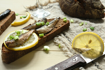 Sandwich with sprats. Sprat in oil. On a wooden background