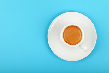 Full white espresso coffee cup over blue