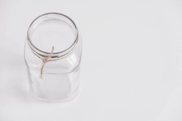 Glass transparent jar on a white table background. Copy, empty space for text
