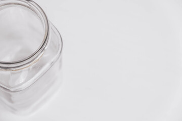 Glass transparent jar on a white table background. Copy, empty space for text