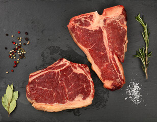 Close up raw beef steaks on black slate board