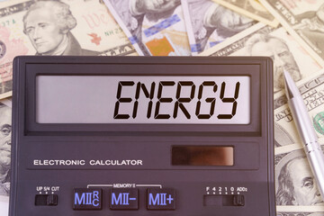 On the table are dollars and a calculator on the electronic board which says ENERGY
