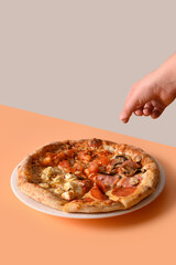 Child take a Italian pizza with different ingredients on beige. Delivery food. Vertical format.
