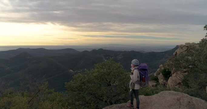monta&ntilde;era mujer mirando horizonte con gorro, mochila y mascarilla pandemia en pico