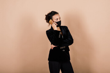 Fototapeta premium Portrait of black businesswoman wearing face mask during virus epidemic in studio.