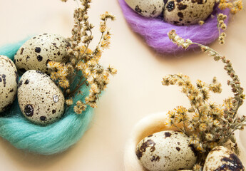 Quail eggs in colored wreaths of wool and dried flowers. Easter decor. High quality photo