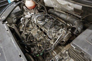 A partially disassembled engine of a modern car is ready for repair. The engine is dirty. Car service, spare parts.