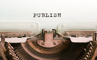 The text PUBLISH is typed on paper by an antique typewriter. Vintage inscription, retro style, grunge, concept.
