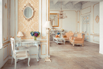 very rich interior of the apartment with golden decorations on the walls in the Baroque style and luxury furniture with gold paint.