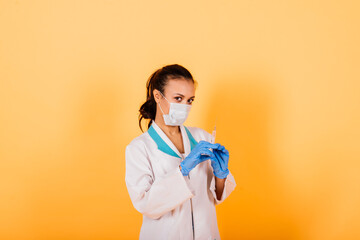 Young smiling African American doctor in medical mask holding a syringe