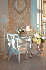 rich apartment interior with golden baroque decorations on the walls and luxury furniture. the room is flooded with the rays of the setting sun