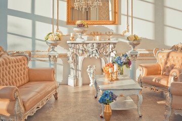 rich apartment interior with golden baroque decorations on the walls and luxury furniture. the room is flooded with the rays of the setting sun