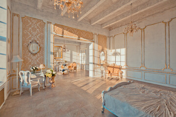 rich apartment interior with golden baroque decorations on the walls and luxury furniture. the room is flooded with the rays of the setting sun