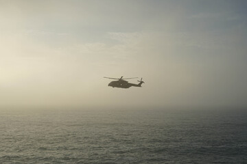 Fototapeta na wymiar helicopter in the middle of the sea with fog