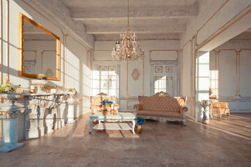 rich apartment interior with golden baroque decorations on the walls and luxury furniture. the room is flooded with the rays of the setting sun