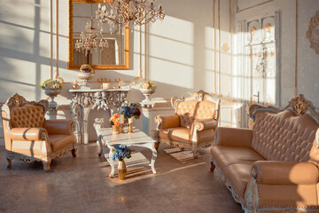 rich apartment interior with golden baroque decorations on the walls and luxury furniture. the room is flooded with the rays of the setting sun