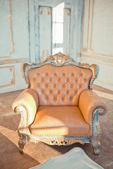 rich apartment interior with golden baroque decorations on the walls and luxury furniture. the room is flooded with the rays of the setting sun