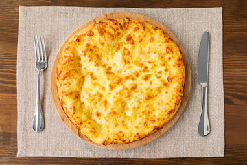 Homemade Megrelian Khachapuri with Sulguni Cheese Filled with a Raw Egg and Melted Butter Close Up.