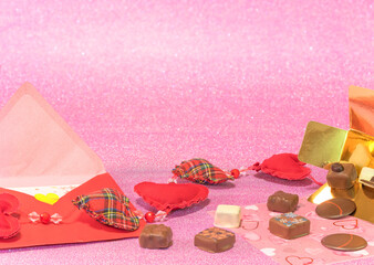 Greeting card depicting chocolates box and a love letter with a scrap heat garland on a glittering pink background celebrating Valentine or white day.
