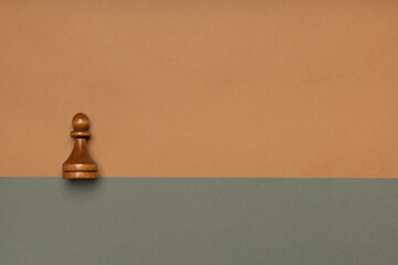 Chess pawn on flat background top view