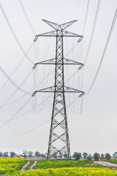 Extra-high voltage 400 kV overhead power line on large pylons, used for long distance, very high power transmission. Cloudy sky and copy space