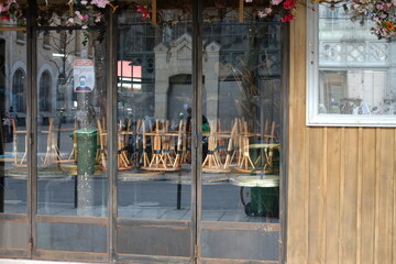 Paris, France - February 4th 2021: Some chairs piled up in a closed parisian restaurant due to the coronavirus pandemic.