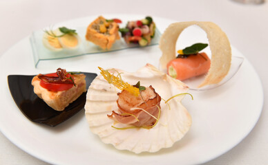 Catering. Colorful meat snacks with bread fruits and vegetables on a white plate.