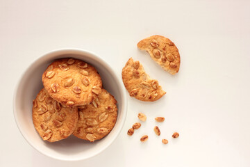 Peanut cookies in a bowl on table. Overhead view of homemade pastry on white background with copy space