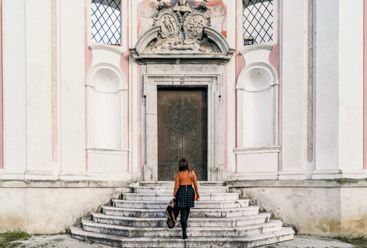 Back View Of A Traveler Female Walking Up Stairs Of An Old Building