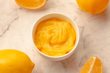 Delicious homemade tangy lemon curd decorated with fresh fruit on marble background.Top view