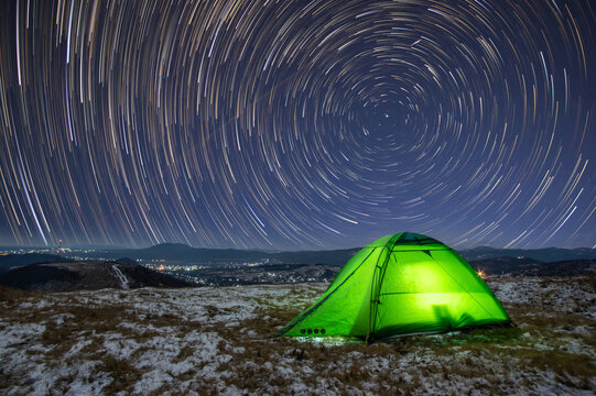 Startrail in winter at night over a tent on a mountain top