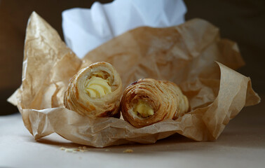 rolls of puff pastry with cream on pastry paper