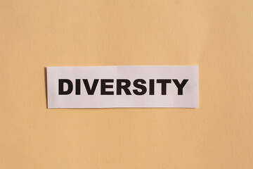 Diversity word written on white paper on beige background. Equality and diversity concept.