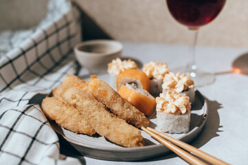 Glasses of wine with Japanese sushi rolls served on plate