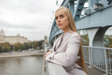 cute stylish  blonde woman in fashionable coat outdoor at autumn day