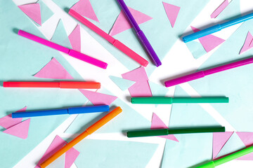 Colorful felt tip pens on a geometric background