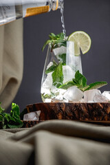 Mojito cocktail on a wooden stand. mint, ice, and white rum.