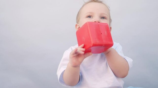 baby drooling bubbles on the lips a toddler play with a cube at home. little boy son portrait close-up. little baby playing at home fun. happy family stay home concept