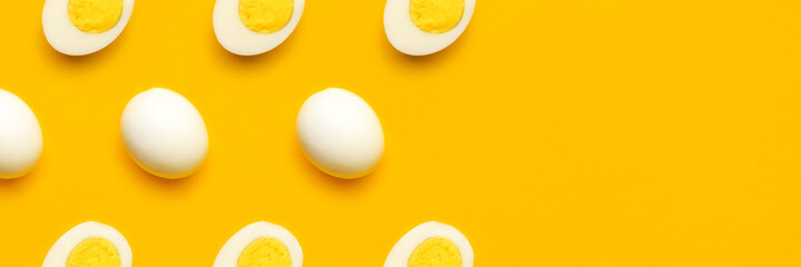 Banner with fresh chicken boiled half cut eggs pattern on yellow background. Healthy food or Happy Easter creative minimal concept. Flat lay, top view