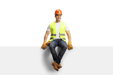 Construction worker with a helmet sitting on a blank panel