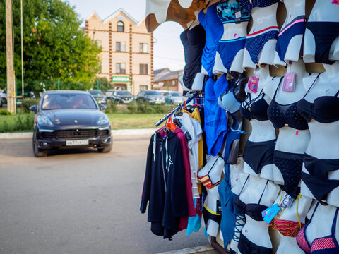 Yeysk. Russia. August 14, 2020. Female bikini swimwear on mannequins in a spontaneous street market in front of a premium car. Everyday life of the resort town in the Krasnodar Territory