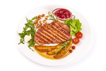 Juicy beef steak with potato wedges and arugula salad with feta cheese, isolated on white background